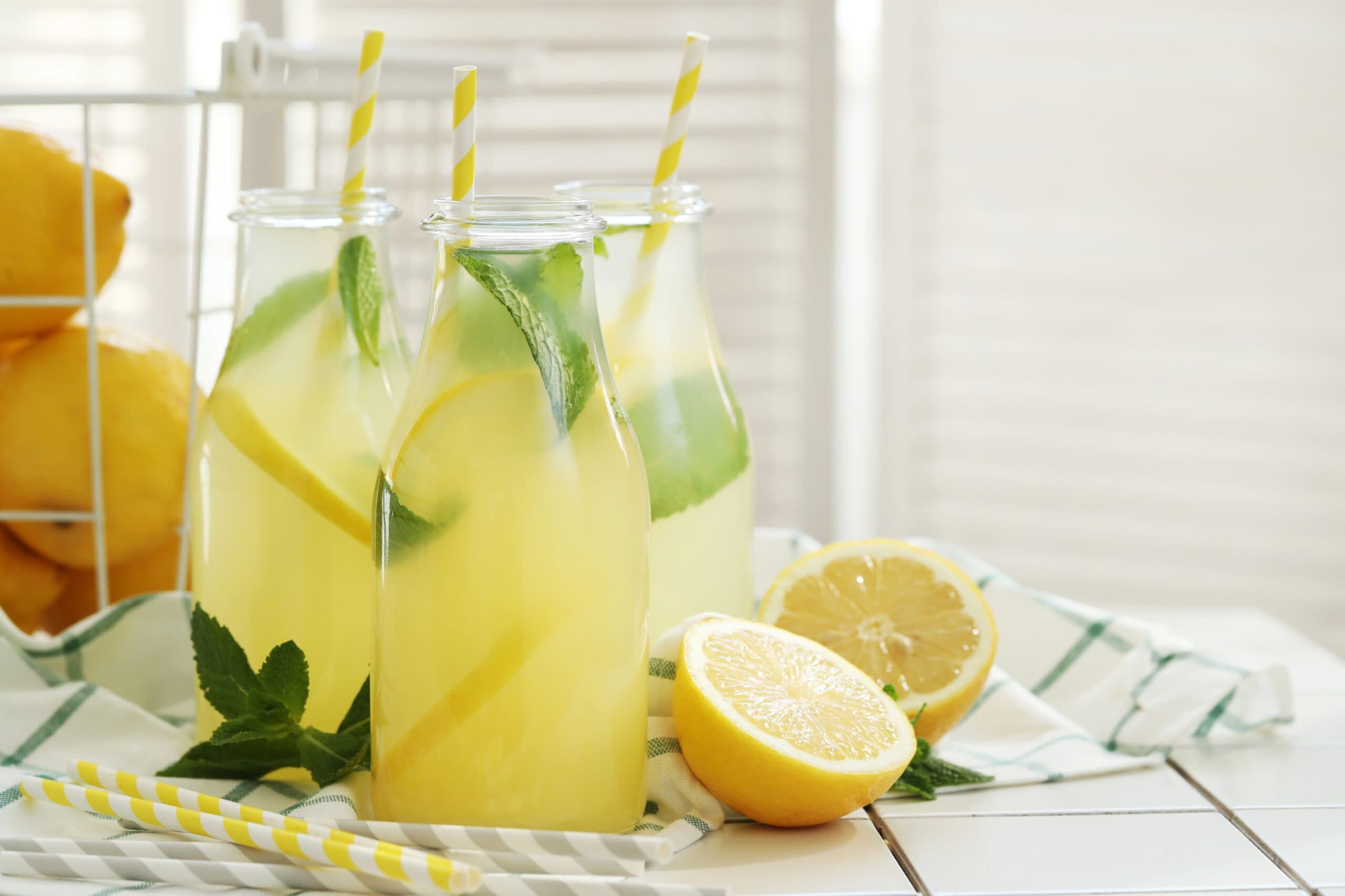 fresh lemonade in glass containers with straws