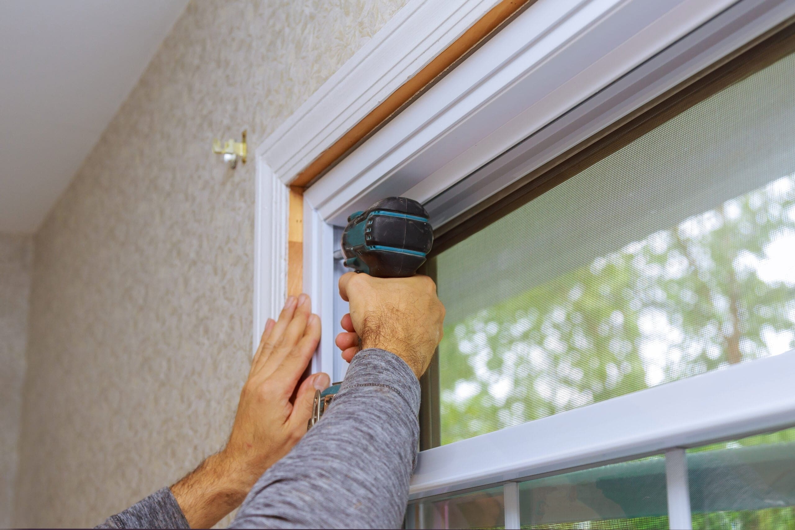 man installing new energy efficient windows in home to reduce air conditioning costs