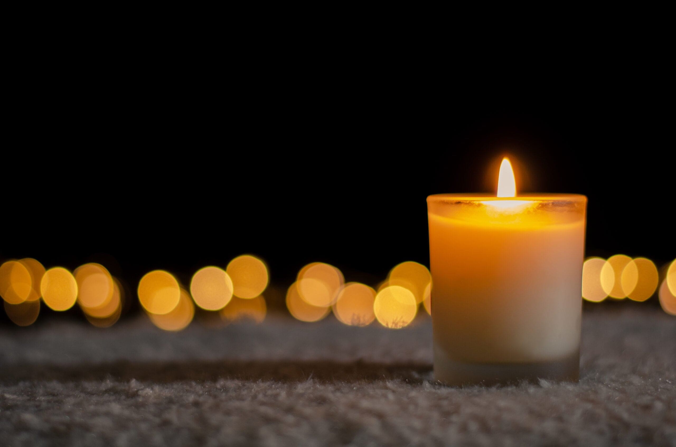 candle lit in home with lights behind