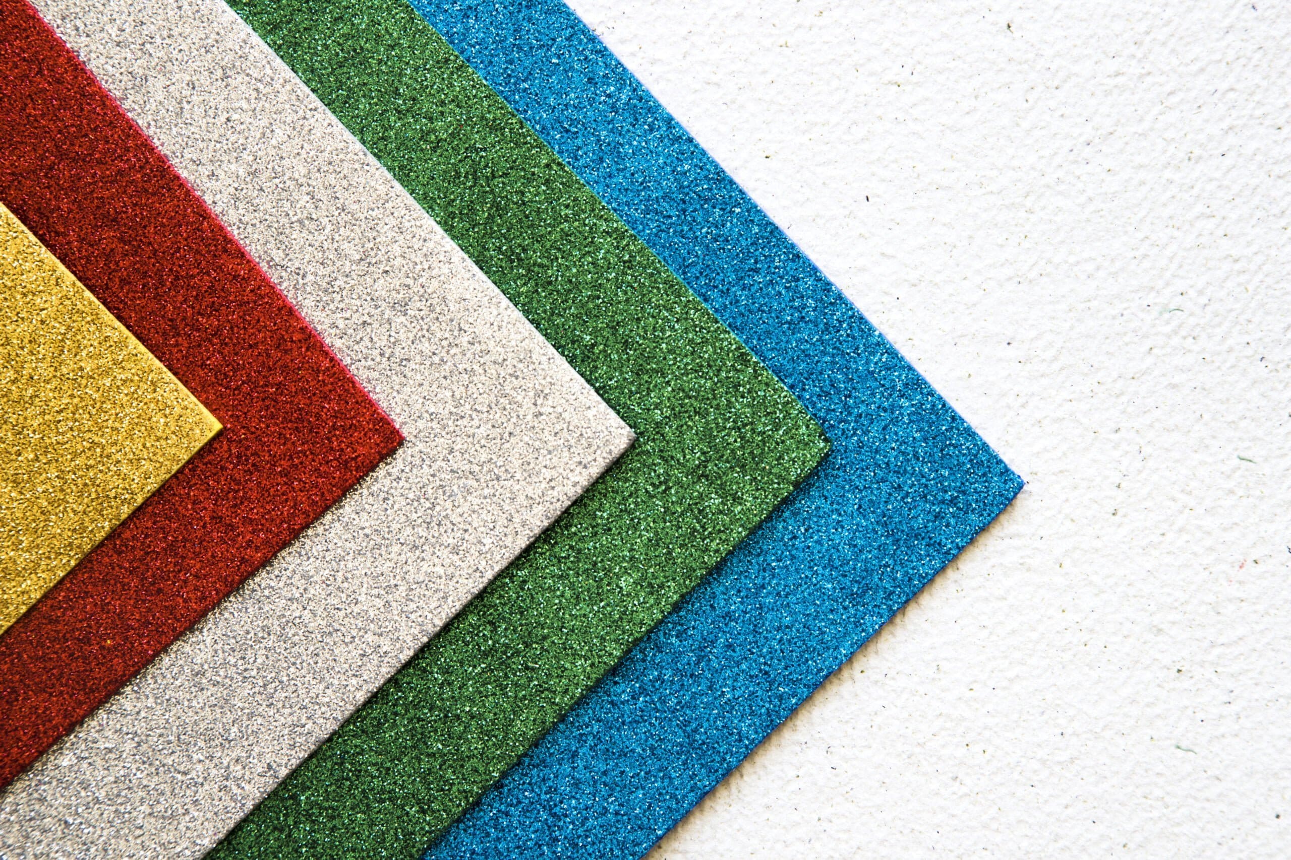 colorful carpet samples against a white concrete floor