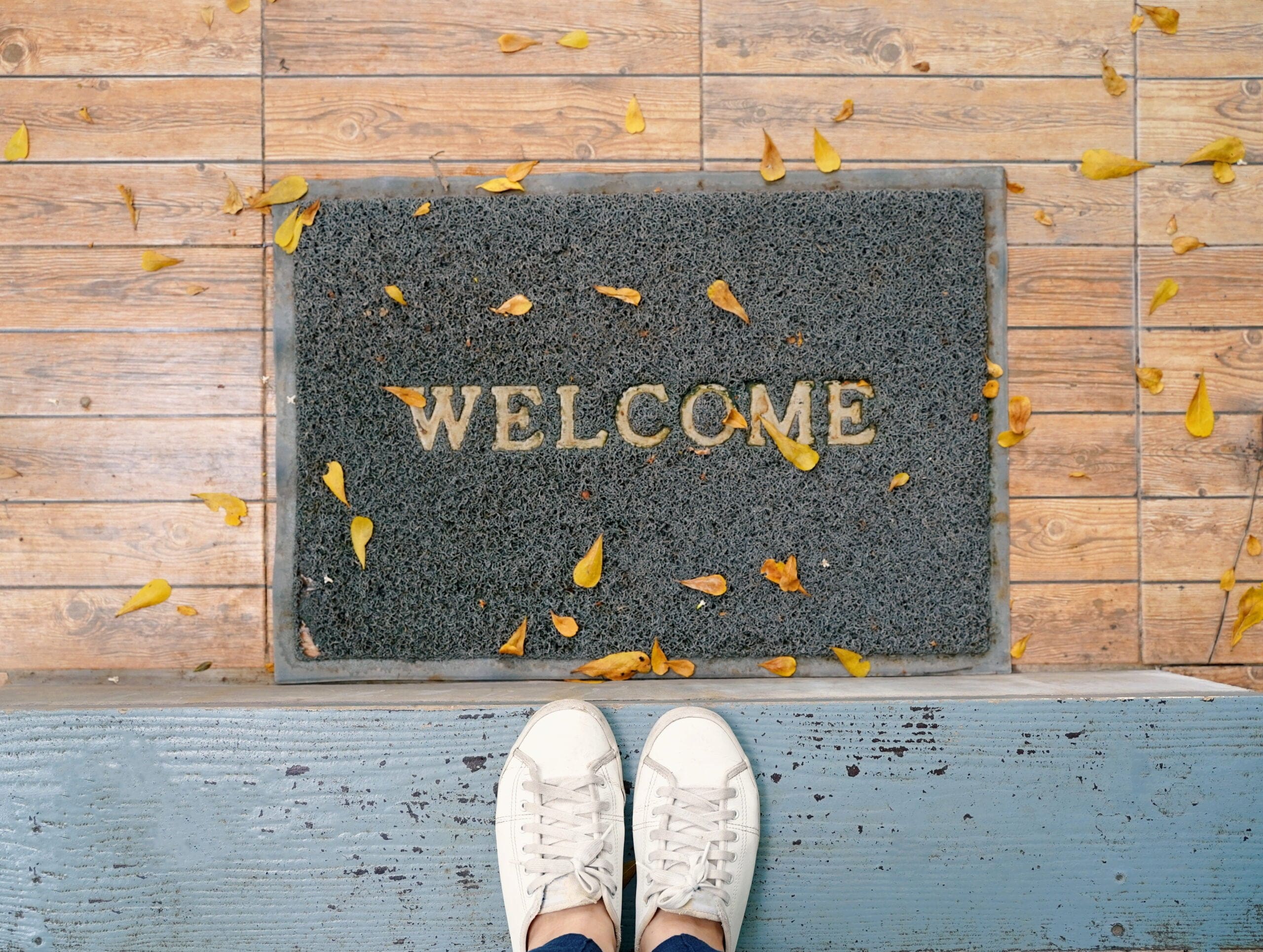 top-view-selfie-feet-white-sneakers-shoes-floor-with-welcome-mat