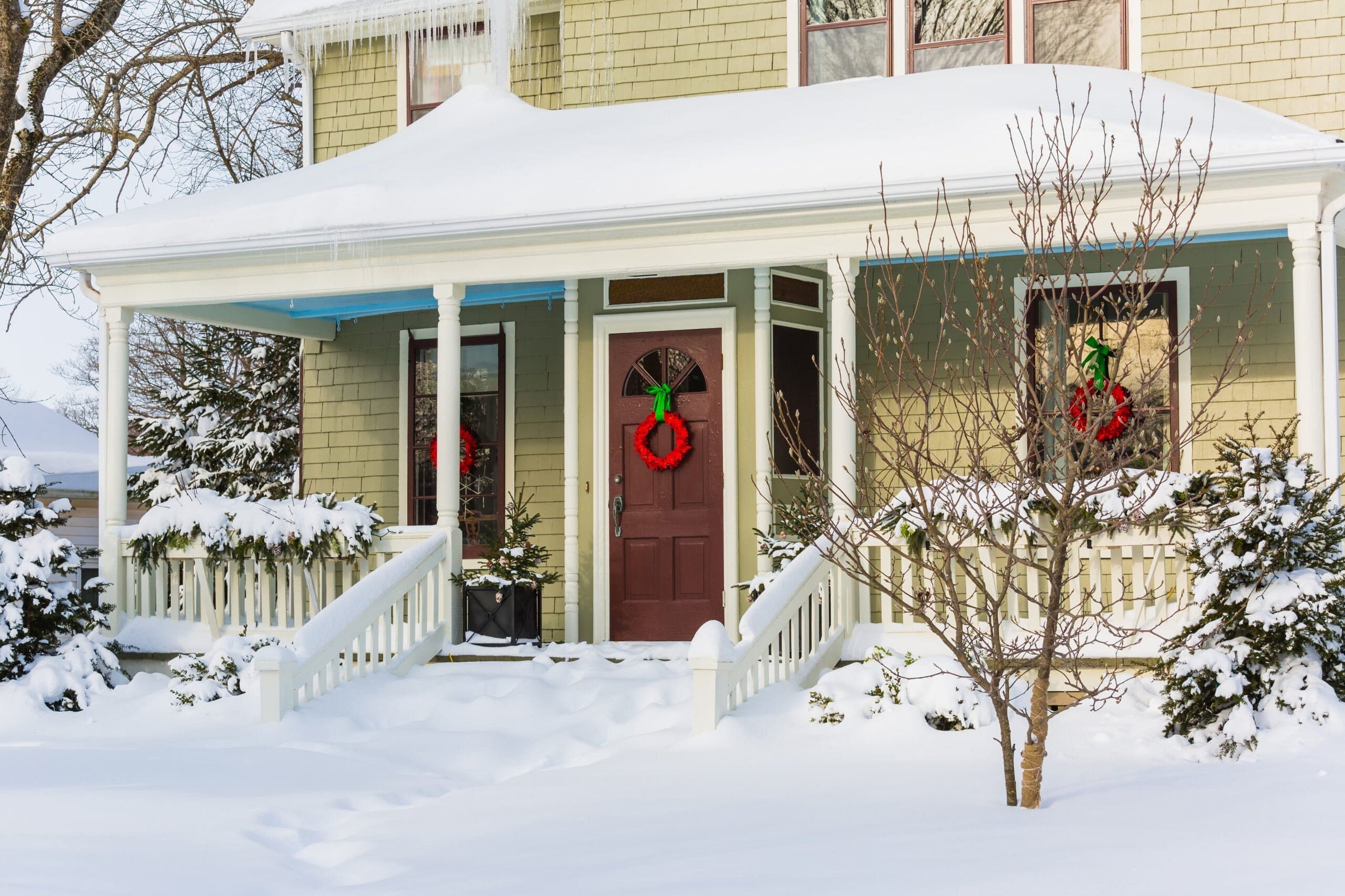 home covered in snow after winterizing your home through fall home maintenance checklist