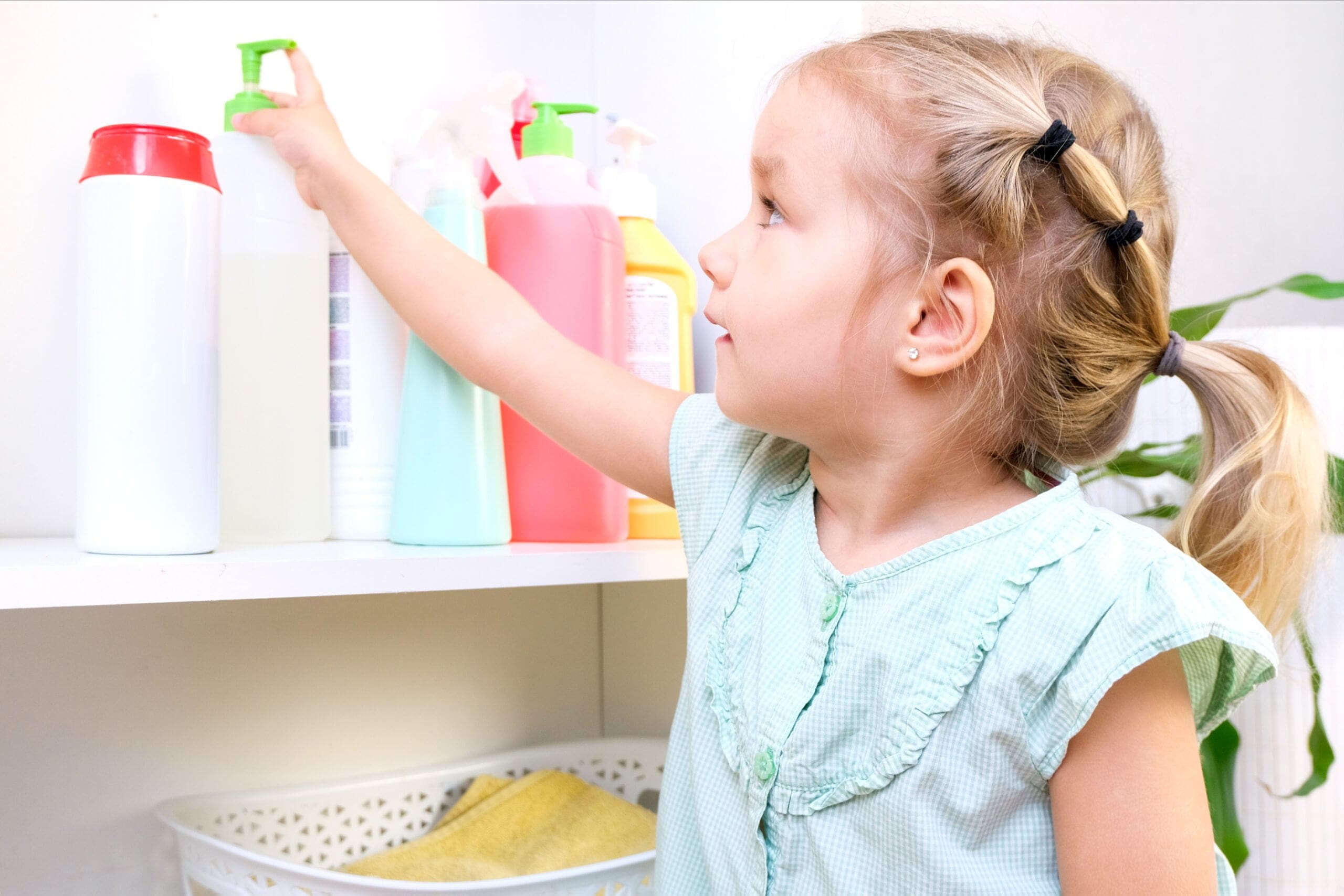toddler-touches-bottles-household-chemicals-household-cleaning-products-dangerous-situation-after-not-childproofing