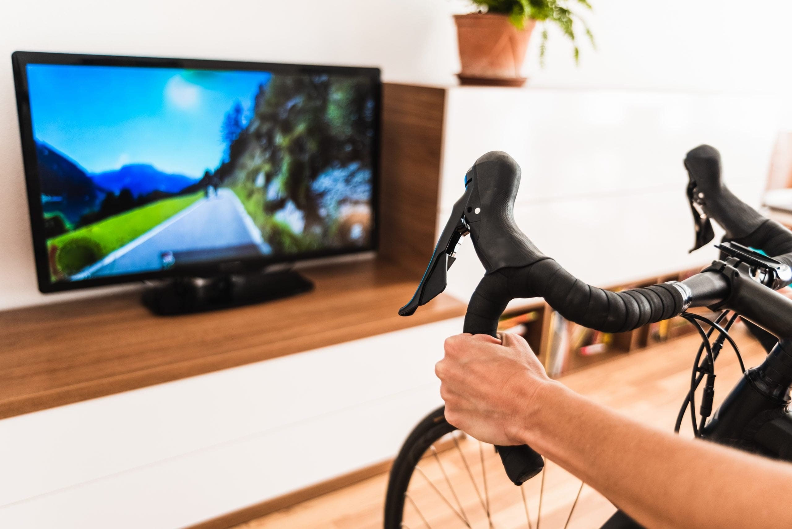 woman-play-online-bike-game-living-room-her-home-sweating-while-doing-pedaling-exercise-connected-internet-her-smart-tv