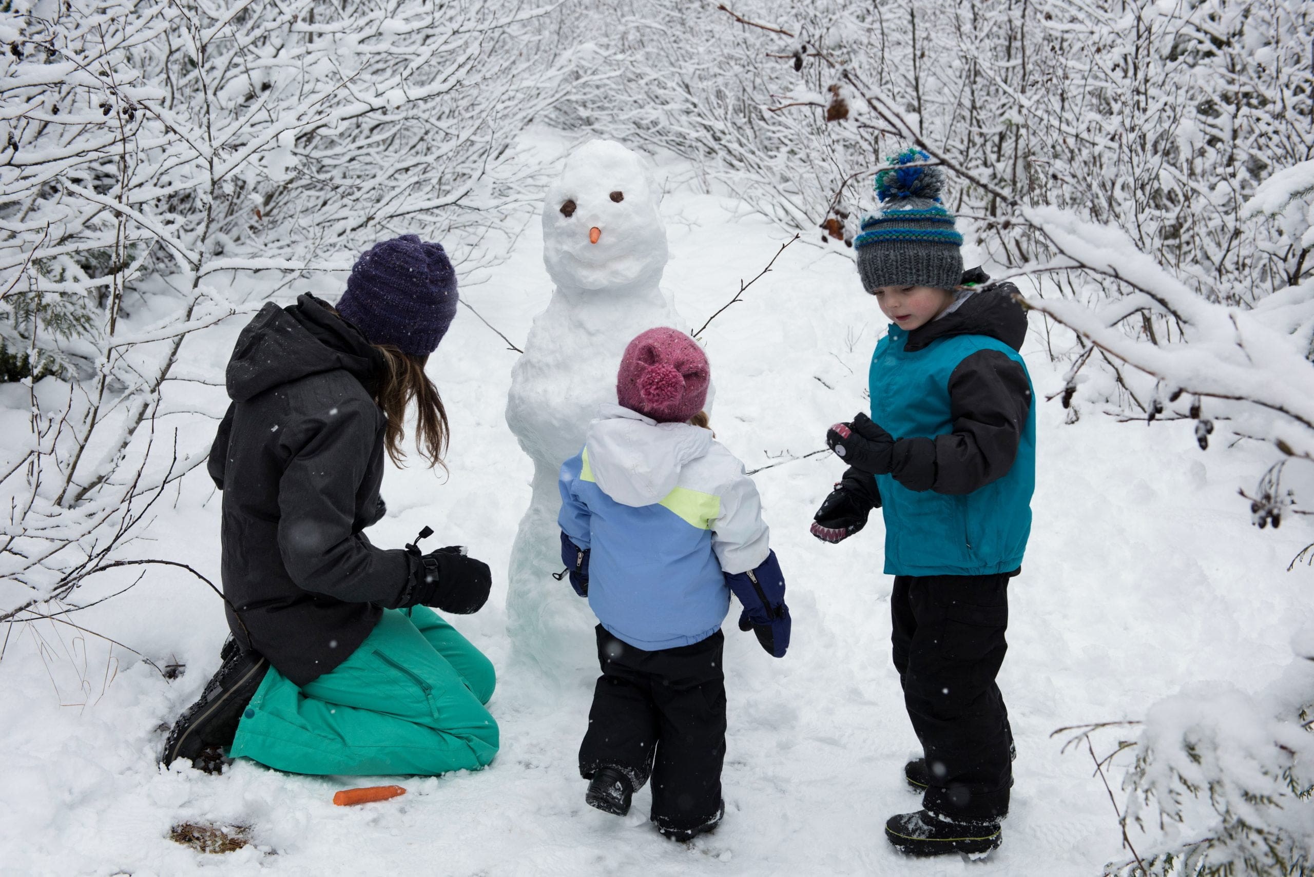 kids building snowman for snow day activities