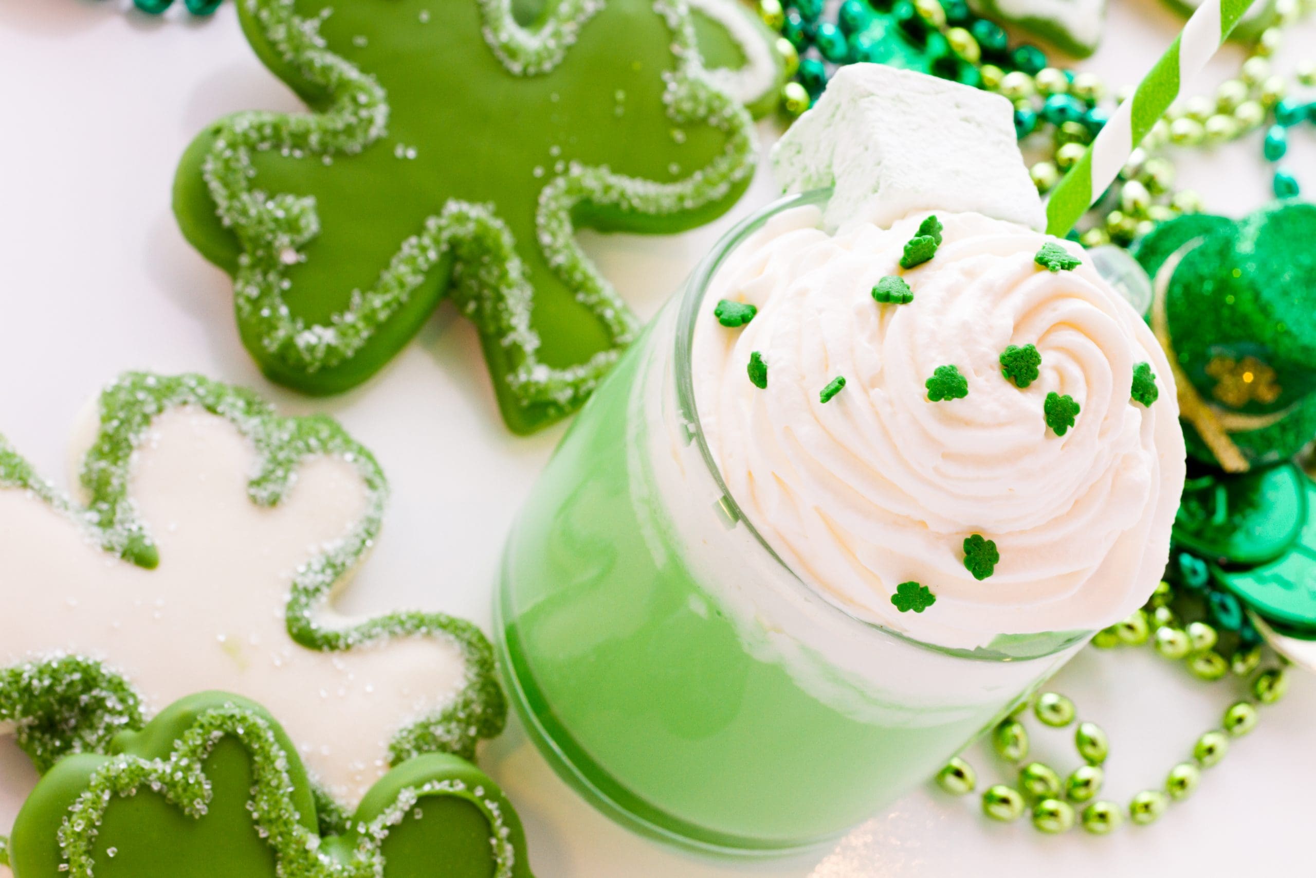 St. Patrick's Day recipes to make at home including clover cookies and mint shake on table
