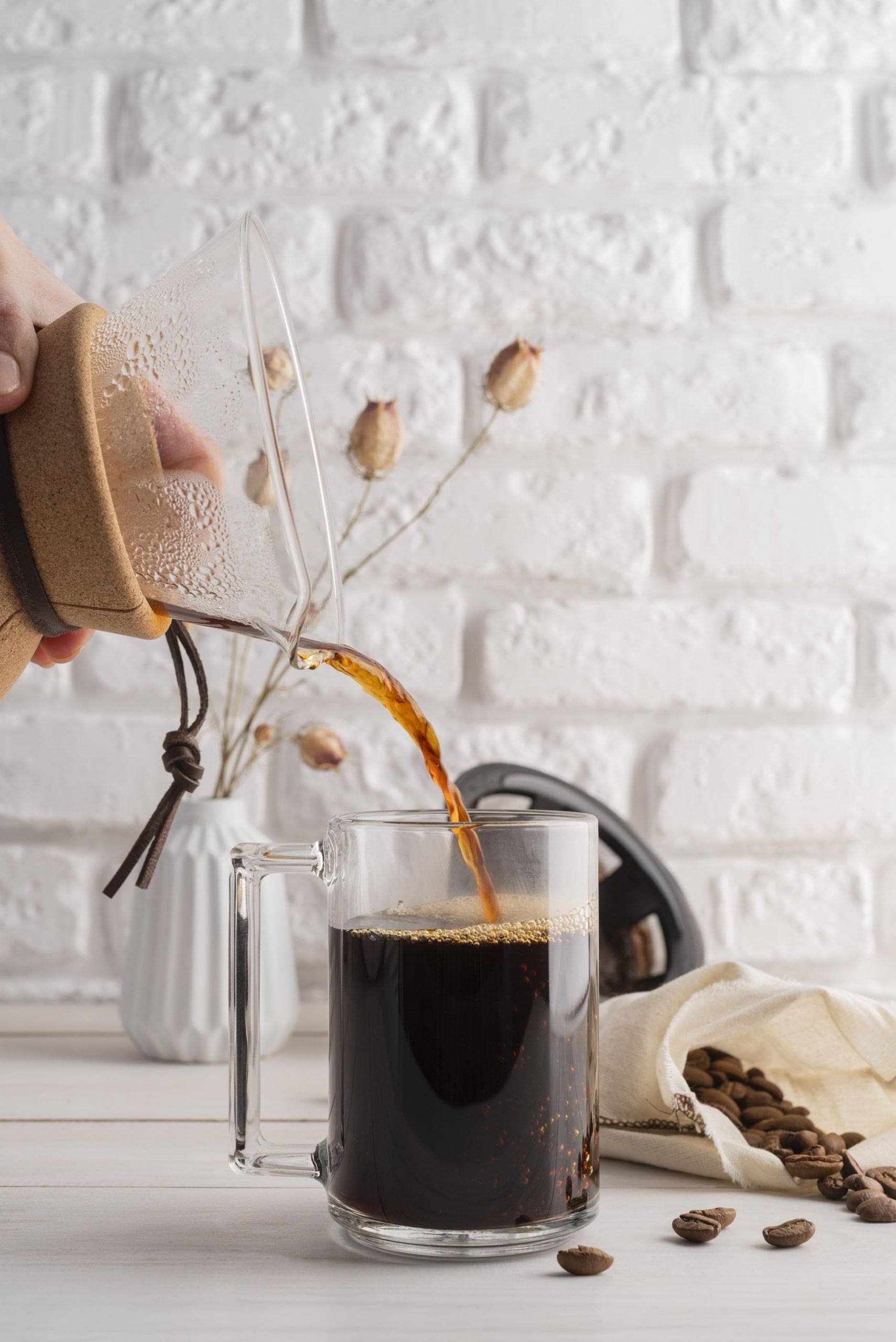 hand pouring mug of coffee at DIY coffee bar at home
