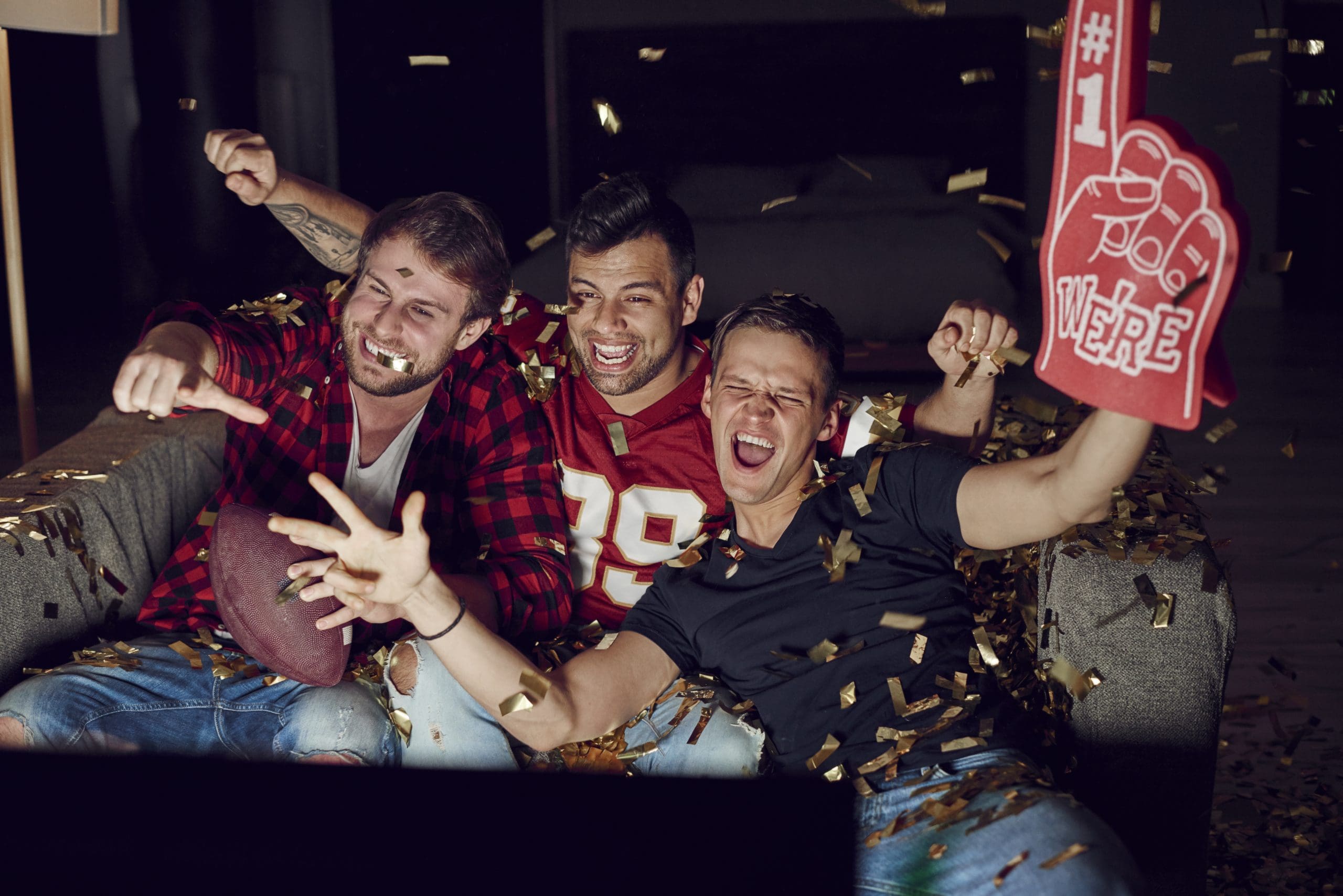 sport fans cheering on favorite team at ultimate super bowl party at home