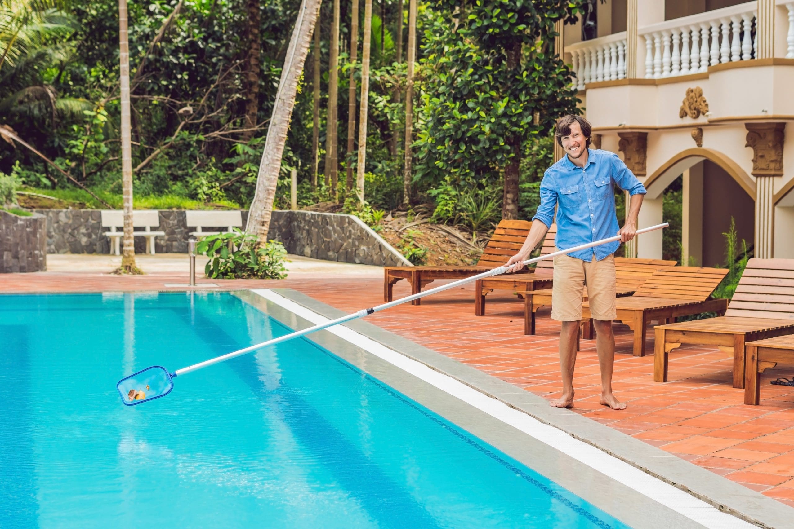 cleaner-swimming-pool-man-blue-shirt-with-skimmer-for-pool-maintenance-and-cleaning