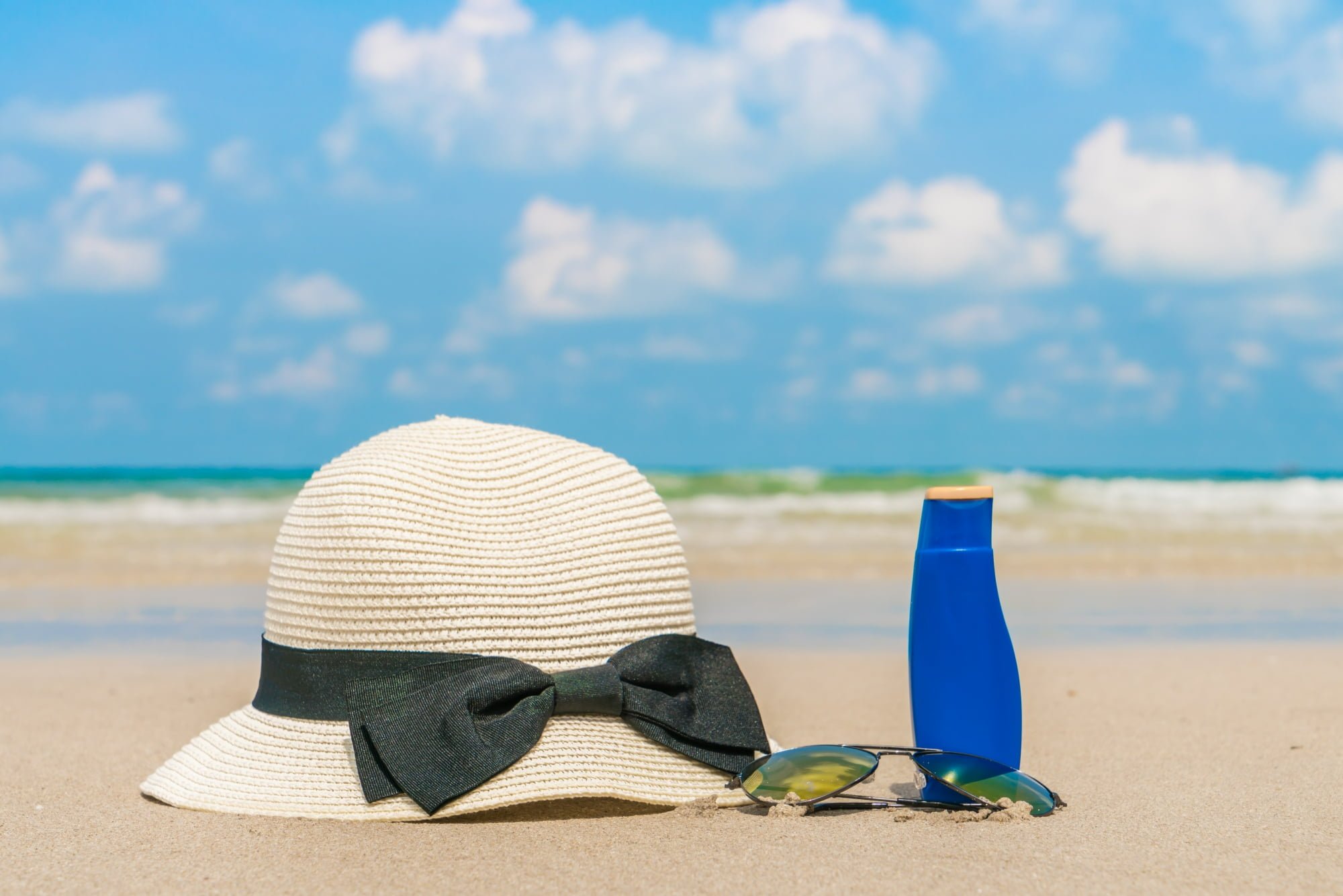sunglasses-hat-and-sunscreen-on-a-beach-for-backyard-sun-safety