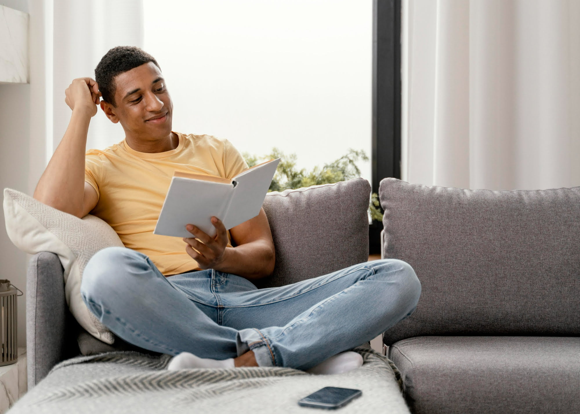 young man reading a book for ways to relax at home