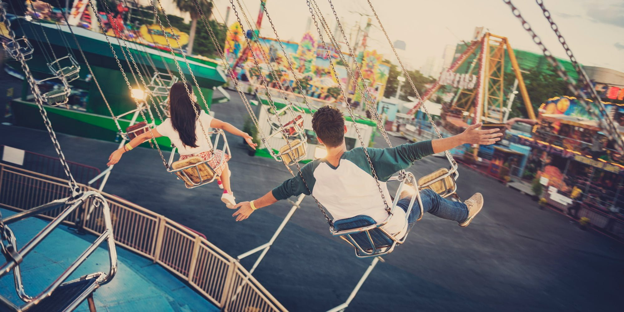 young woman and man on swings ride at one of the family amusement parks near Saratoga County