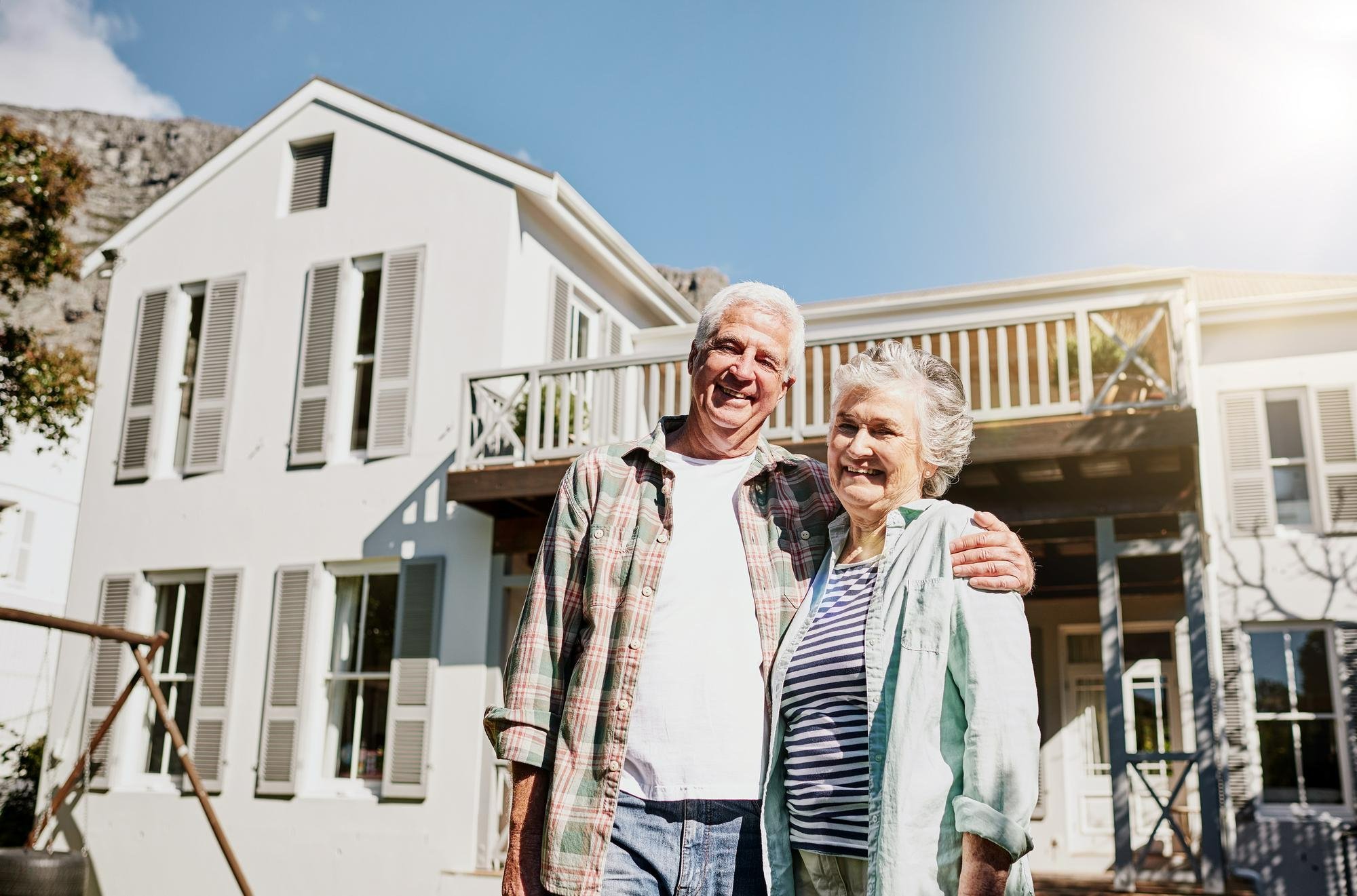 senior-couple-standing-in-front-of-home-after-building-a-home-for-aging-in-place